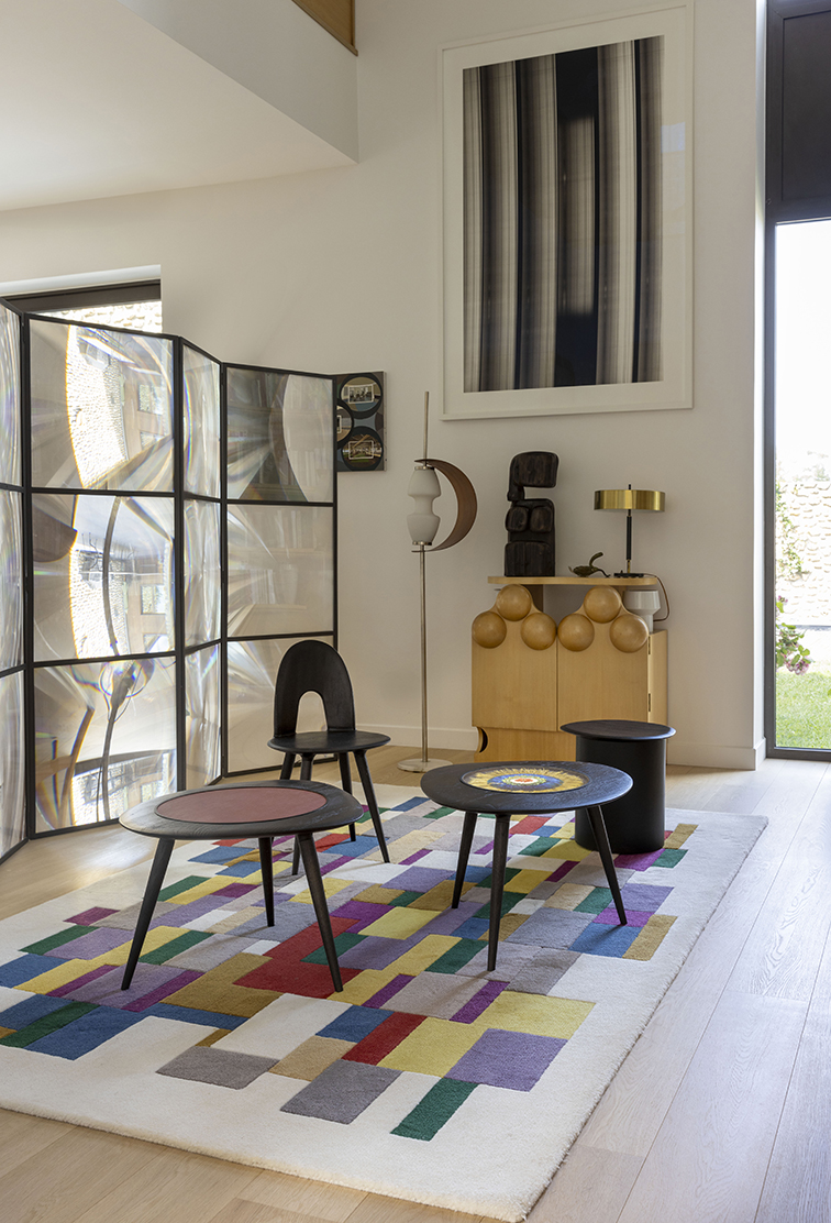 Salon moderne avec meubles design et tapis coloré.