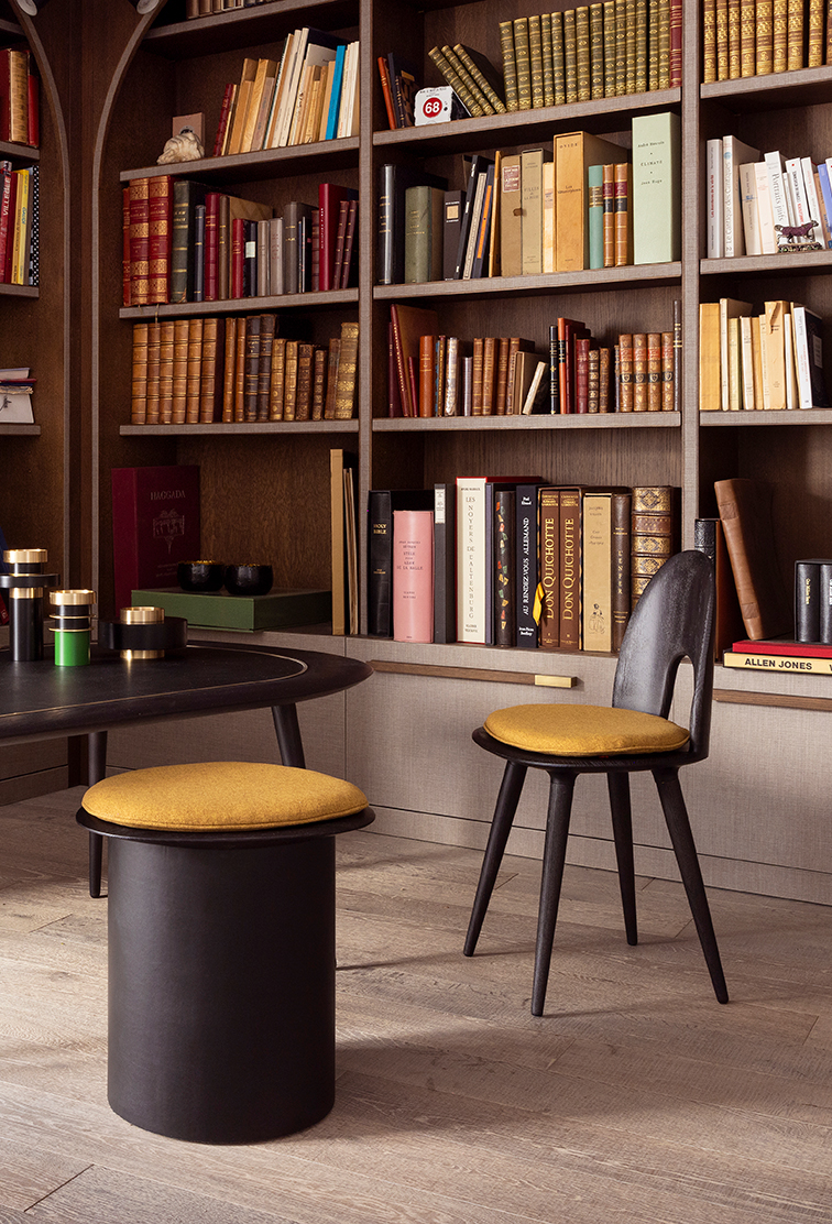 Bibliothèque avec livres anciens et chaises modernes.