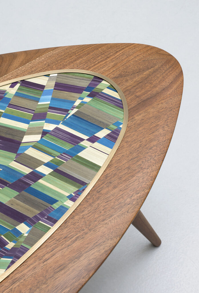 Table en bois avec détails colorés géométriques.