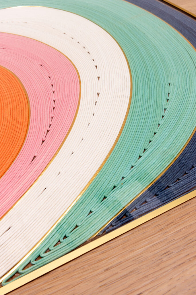 Couches de papier multicolores en spirale sur bois.