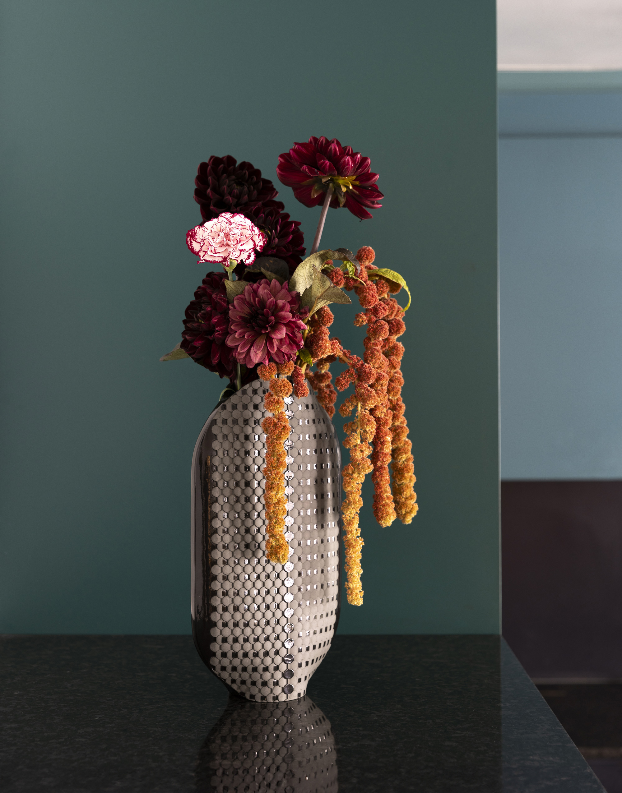 Bouquet de fleurs dans un vase moderne argenté.